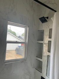 a bathroom with white walls and a window