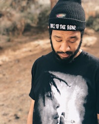 a man wearing a black beanie with a picture of weed on it