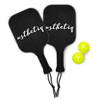 a black paddle and yellow ball with the word athleticity