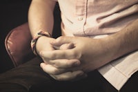 a man sitting in a chair with his hands on his knees