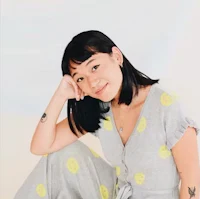 a woman in a grey jumpsuit posing for a photo