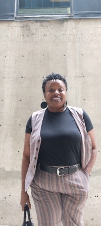 a black woman standing in front of a building