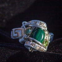 a ring with a green stone on it