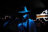 a man in a hat singing into a microphone