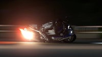 a motorcycle rider on a dark road at night