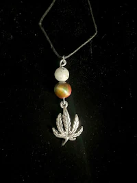 a necklace with a marijuana leaf on it