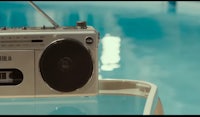 a boombox sitting on top of a table next to a pool
