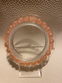 a pink bead ring on a mirror