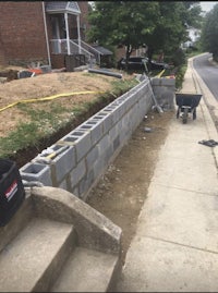 a retaining wall being built in front of a house