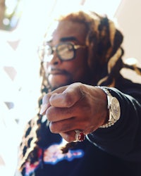 a man with dreadlocks pointing to the camera