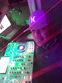 a man in a hat with a dj deck in front of him