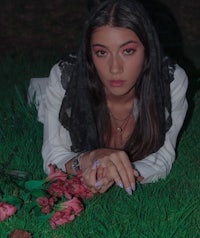 a woman laying in the grass with flowers