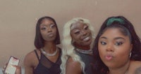 three women are posing for a selfie in a bathroom