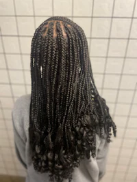 the back of a girl with braided hair in a bathroom