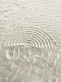 a black and white photo of a rainbow in the sand