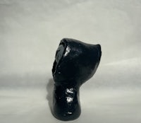 a black hooded figure on a white surface