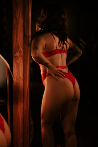 a woman in a red lingerie standing in front of a mirror