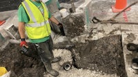 a man in a yellow vest is working on a construction site