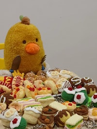 a stuffed animal is sitting in front of a table full of food