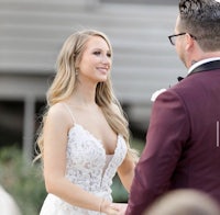 a bride and groom look at each other during their wedding ceremony