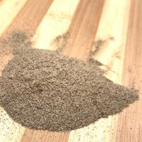 a pile of brown powder on top of a wooden cutting board