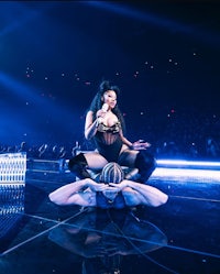 nicki minaj performs on stage with a woman on top of her
