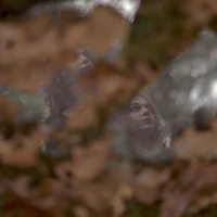 a woman is reflected in a mirror in the woods