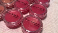 a group of pink lip balms on a table