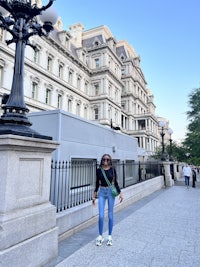 a woman standing in front of a large building