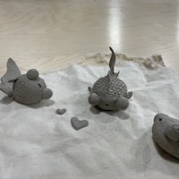 three clay figurines on a piece of cloth