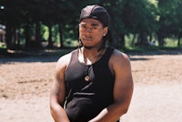 a man in a black tank top standing in a field