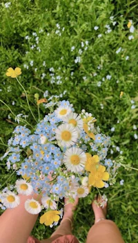 a person holding a bouquet of flowers in the grass