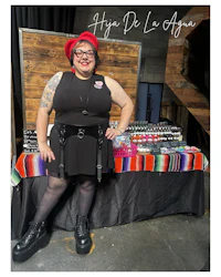 a woman in a black dress standing next to a table