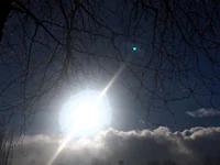 the sun shines through a cloudy sky