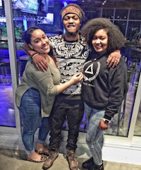 three women posing for a picture with a man