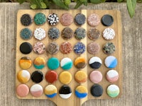 a wooden board with a variety of colored stones on it