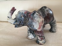 a ceramic elephant statue on a couch