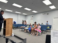 a man speaking to a group of children in a church