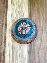 a stone with a spiral on it on top of a wooden table