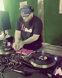 a man with a beard playing a dj set