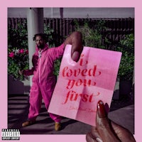 a man holding a pink card with the words i loved you first