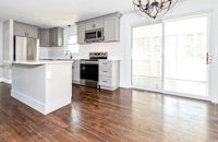 a kitchen with hardwood floors and stainless steel appliances