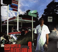 a man in a white shirt is standing in front of a gas station