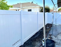 a white fence is being installed in a backyard
