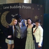 three girls posing for a photo in front of a poster