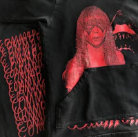 a black hoodie with an image of a woman and a shark