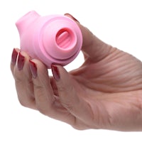 a woman's hand holding a pink sex toy