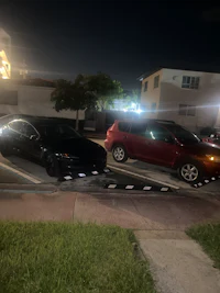 two cars parked in a parking lot at night