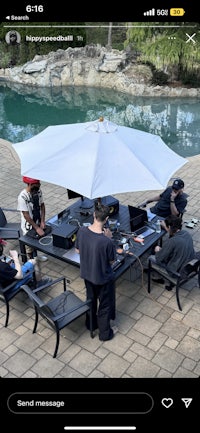 a group of people sitting around a table with an umbrella