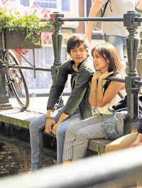 a group of people sitting on a bridge